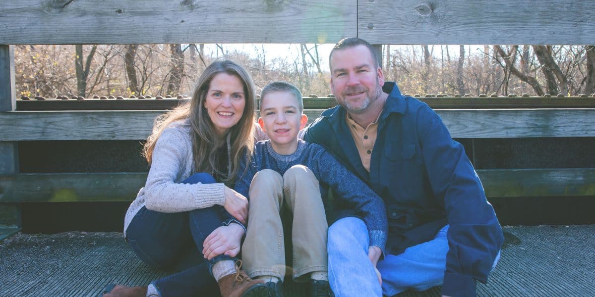 blogger, husband and son sitting on a bridge