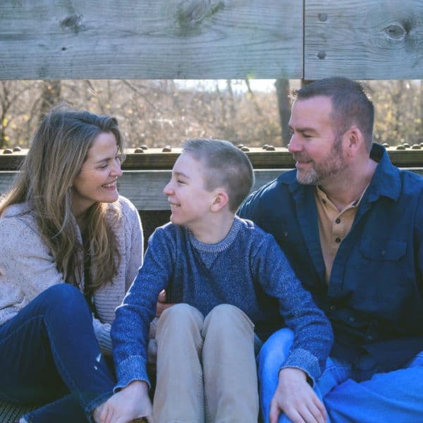 blog creator, her son and husband sitting on a bridge