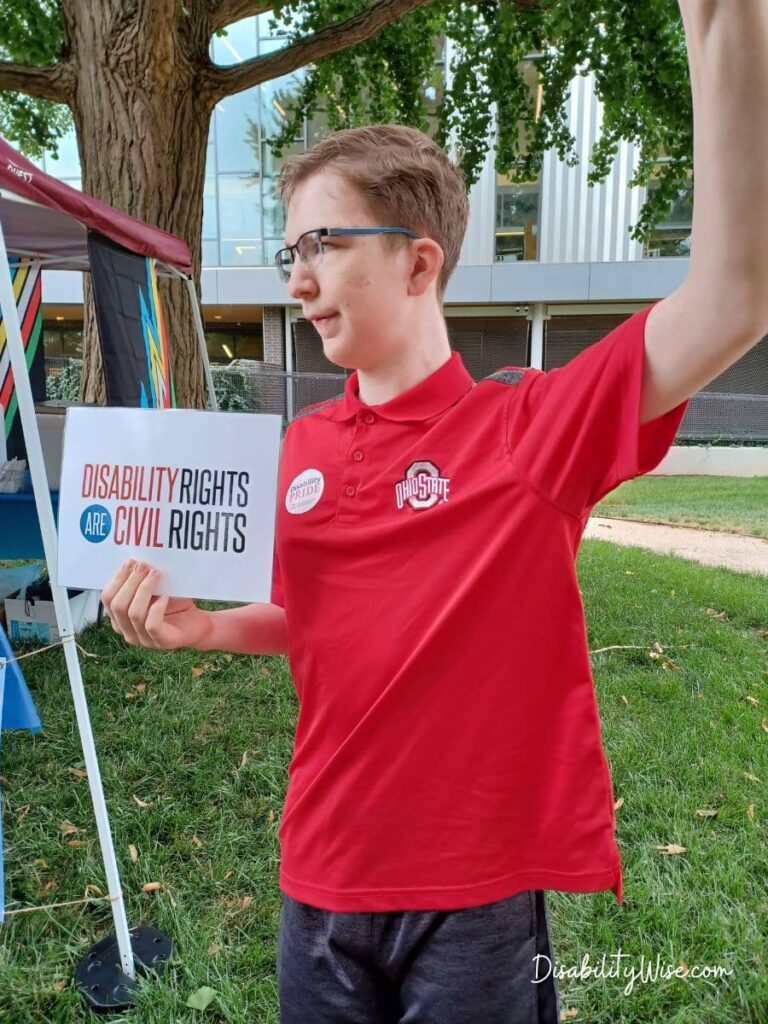 teen boy with developmental disability holding a sign for civil rights