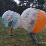 two teens in bubble suits enjoying summer