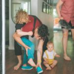 Parent of child with a disability putting on shoes the child