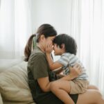 Grieving mother and young son sitting on a couch looking at each other