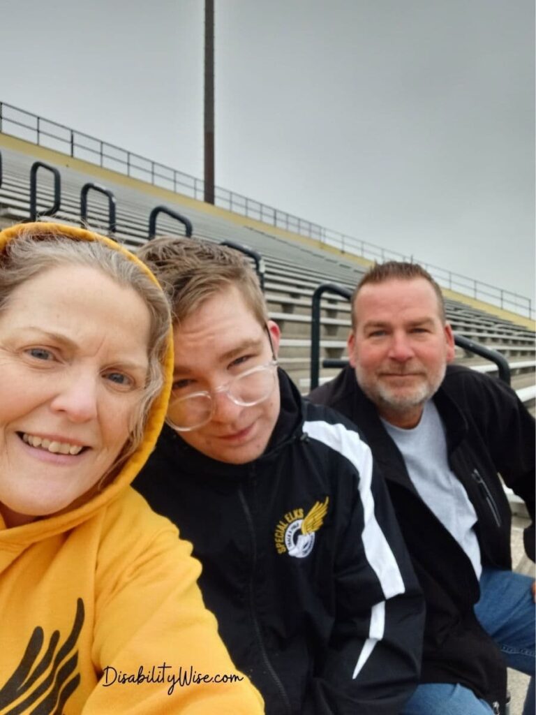 Grieving mother and father, with teen son with disabilities taking a selfie 