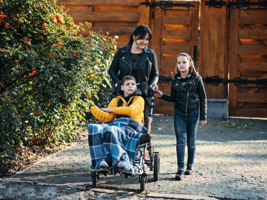 Boy with disability in a wheel chair with his mom and sister